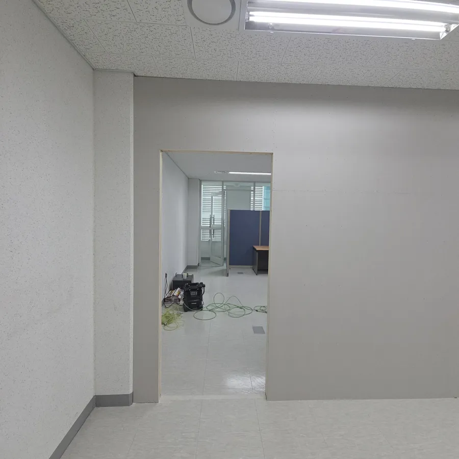 석고보드로 면이 막힌 회색 가벽과 출입구 개구부
